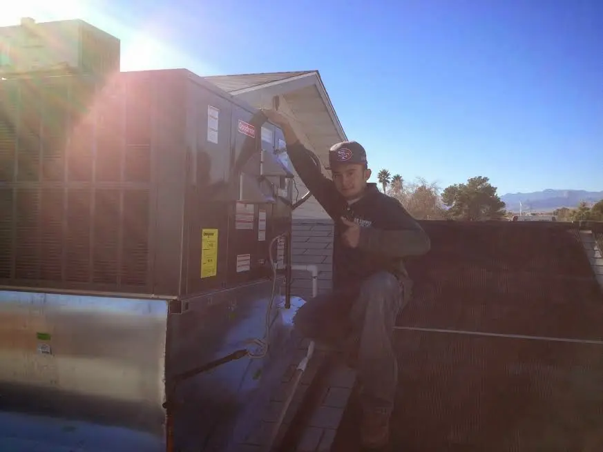 HVAC technician performing Air Duct Cleaning on a rooftop unit in Fairbanks